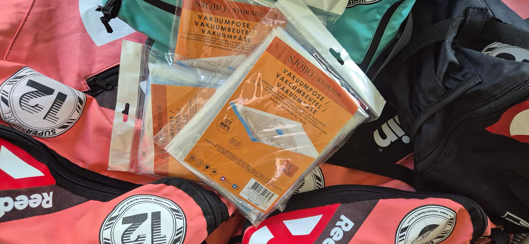 Sjöbo opbevaringsposer og vakuumposer placeret over farverige kites klar til kompakt pakning