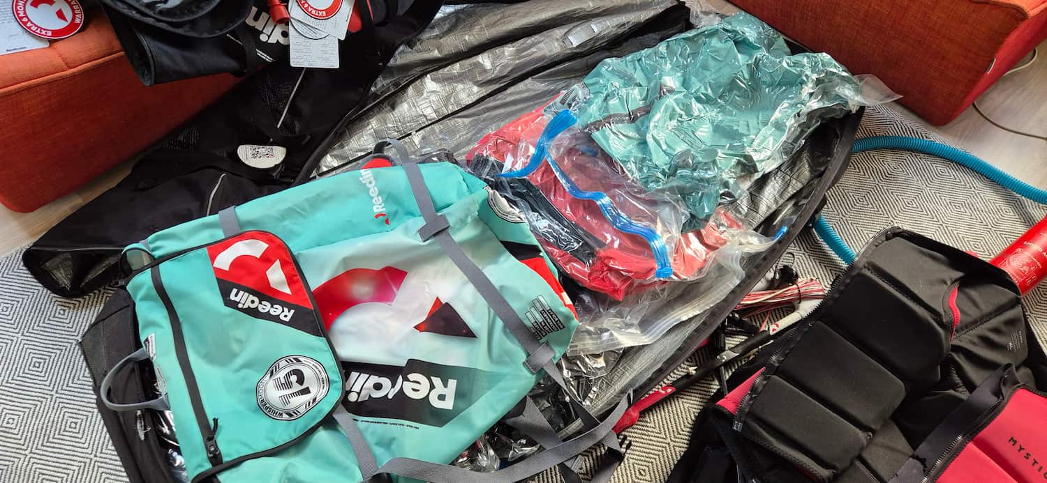 Arranging compressed vacuum packed kites neatly into the bottom layer of a flight kiteboard bag